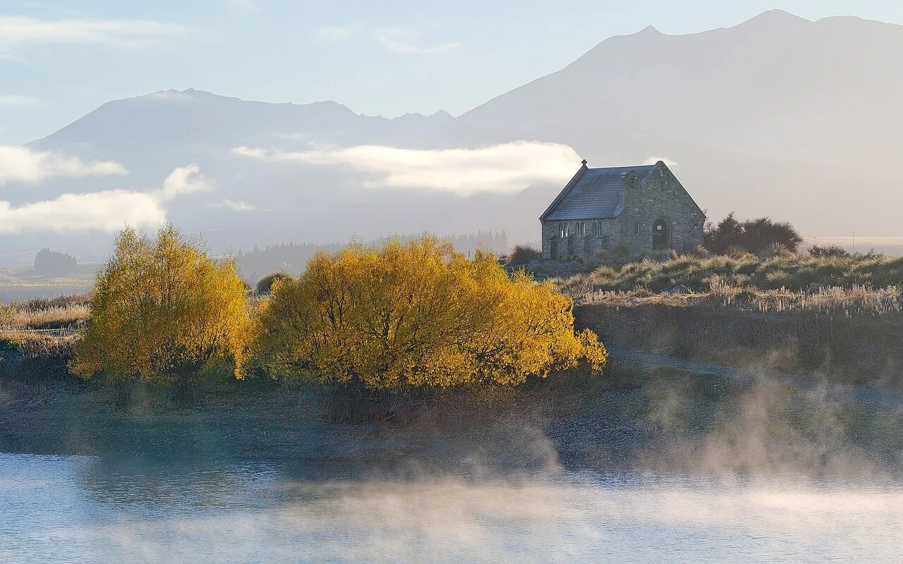 A cold, still lake under mist on a late autumn morning