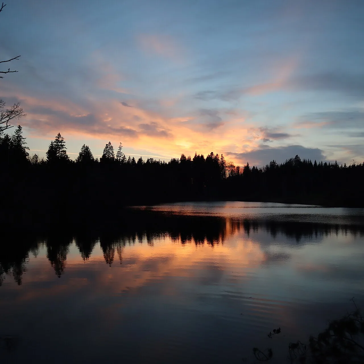 Calm water on a lake at dusk